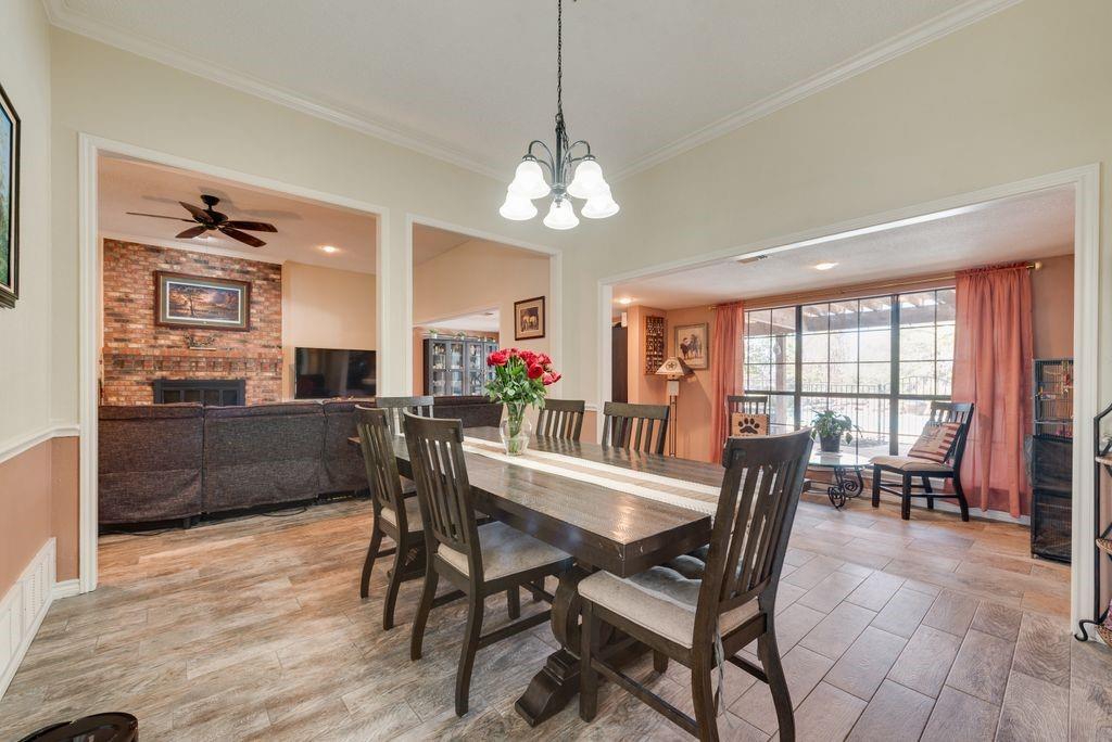 83 Crown Road Willow Park, TX 76087 - Photo 5 of 35 Spacious dining area with wood-finish flooring, crown molding, and a multi-light chandelier