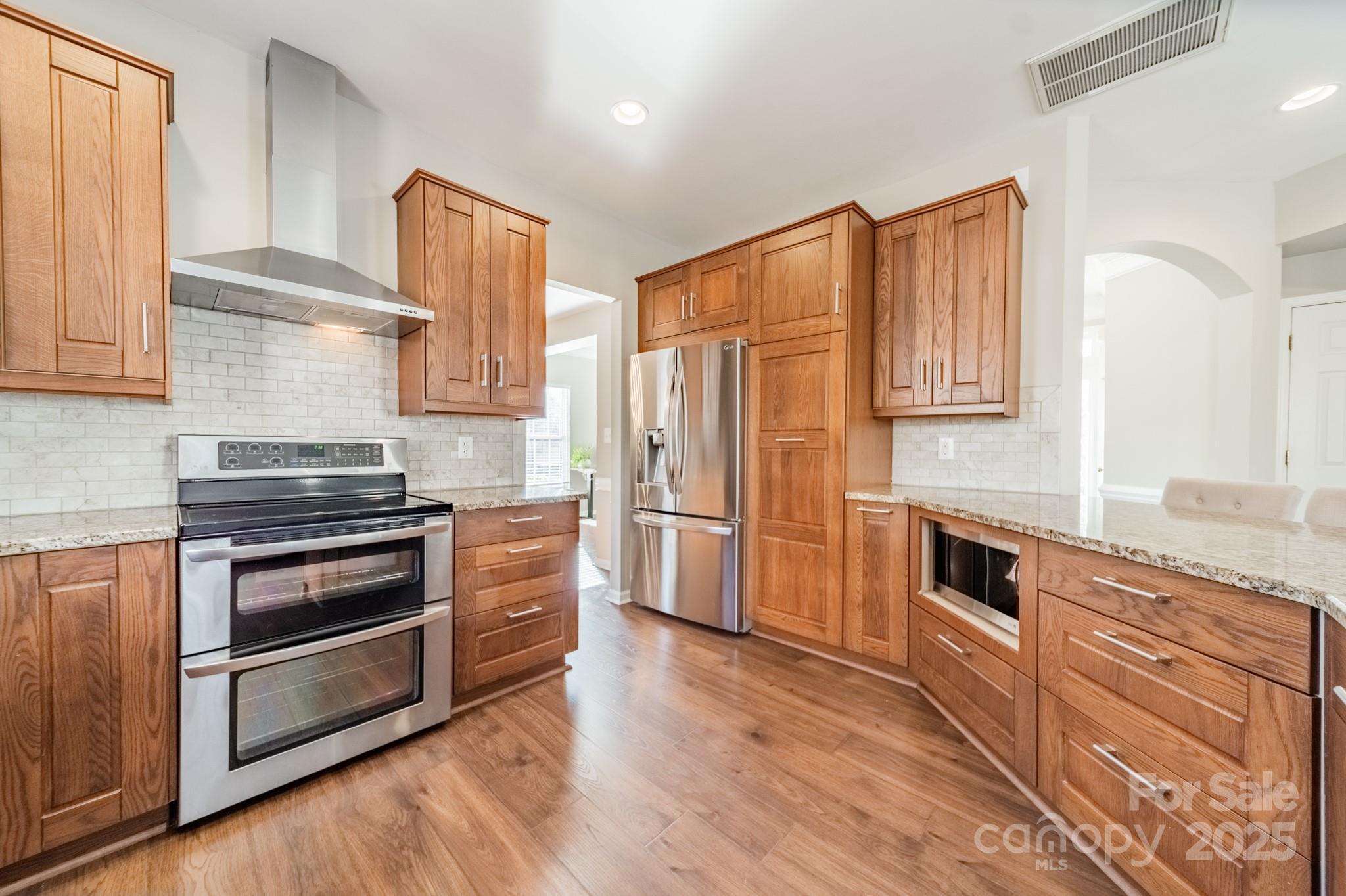 16104 Hollingbourne Road Huntersville, NC 28078 - Photo 11 of 40 a kitchen with granite countertop wooden floors stainless steel appliances and cabinets