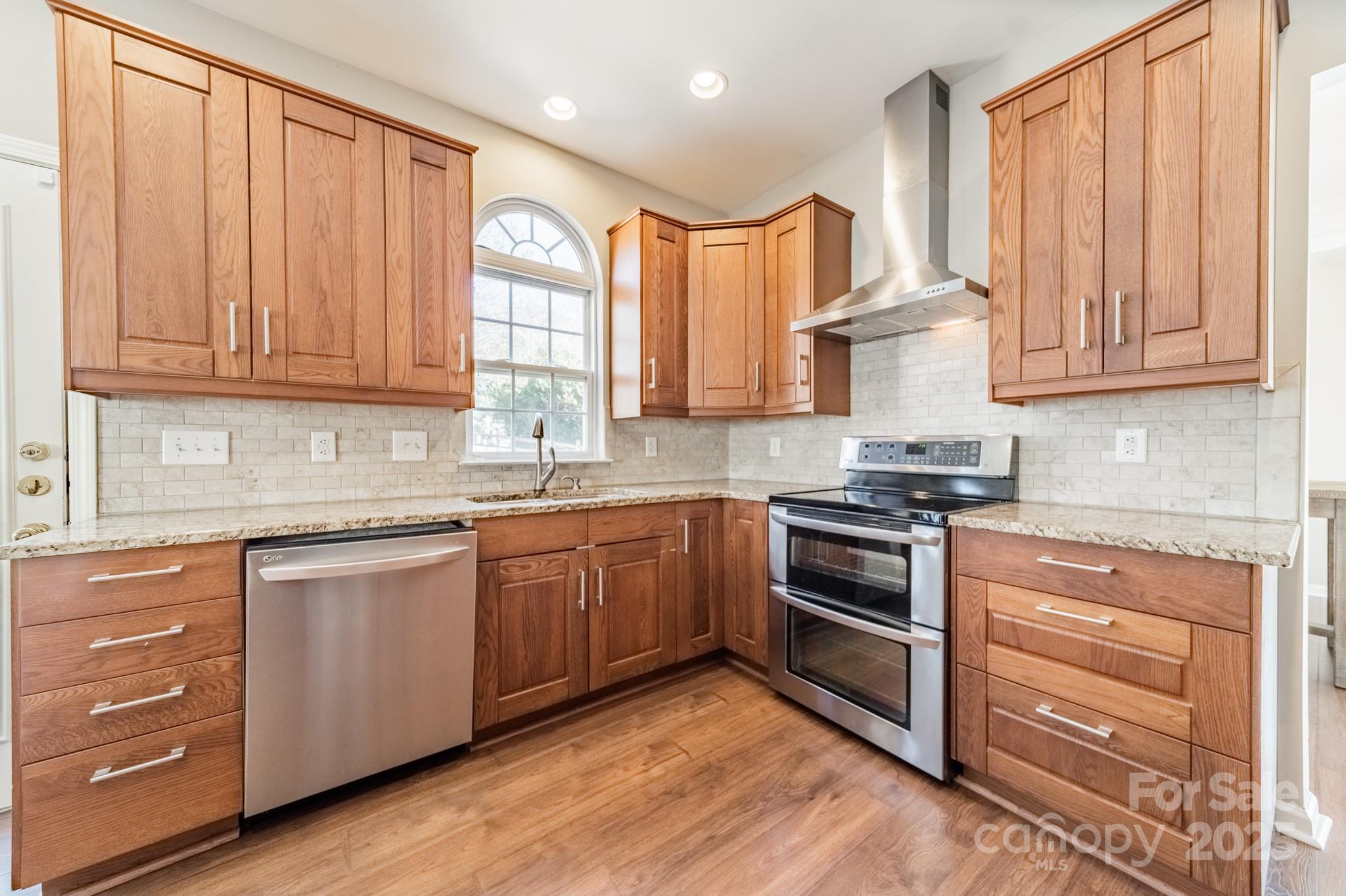 16104 Hollingbourne Road Huntersville, NC 28078 - Photo 12 of 40 a kitchen with granite countertop wooden cabinets and white appliances