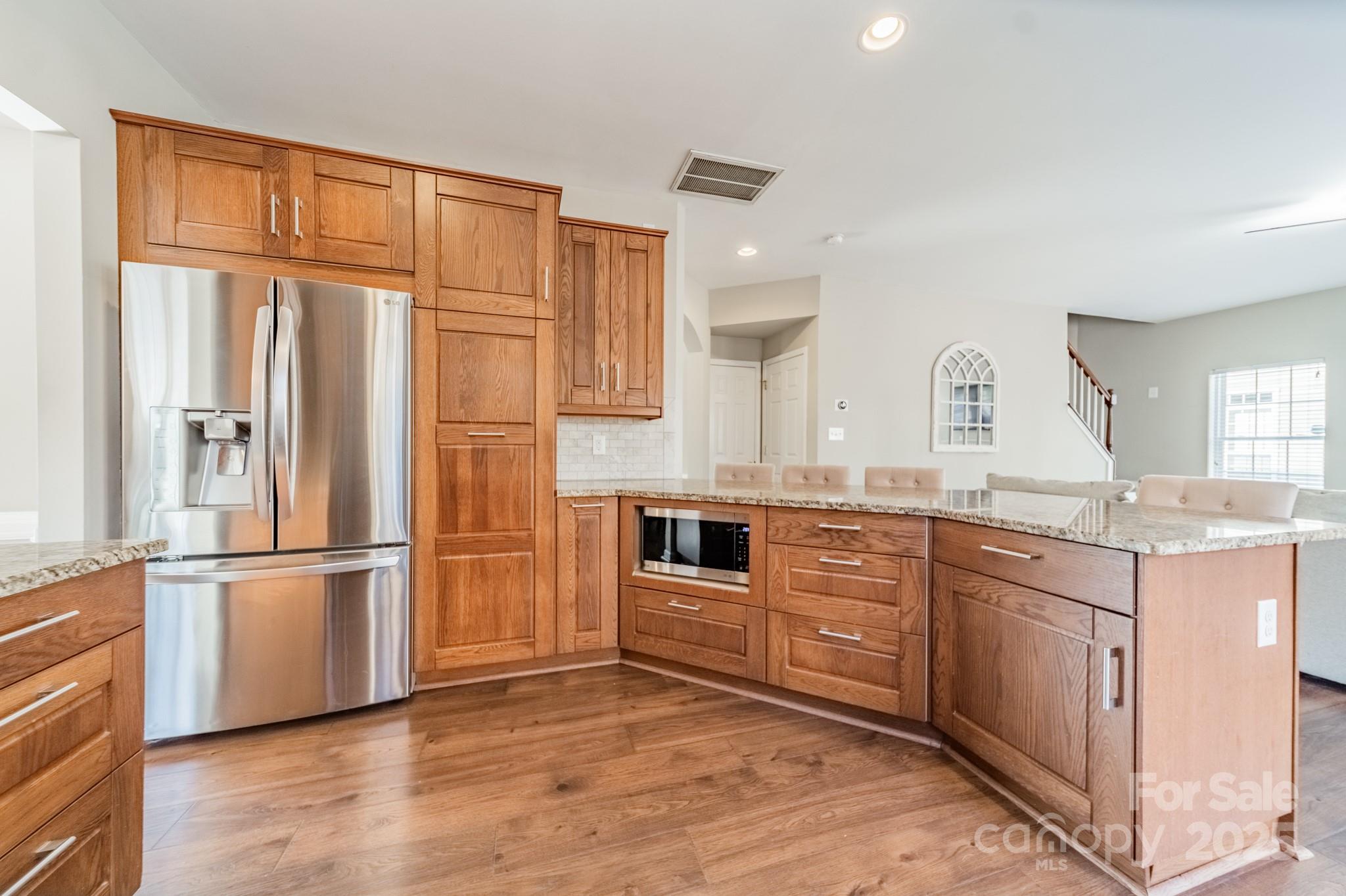 16104 Hollingbourne Road Huntersville, NC 28078 - Photo 13 of 40 a kitchen with stainless steel appliances granite countertop a refrigerator oven a sink dishwasher and white cabinets with wooden floor