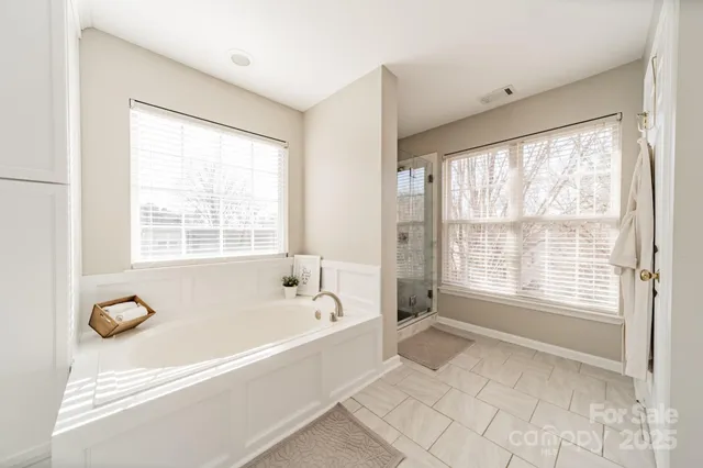 a spacious bathroom with bathtub and shower