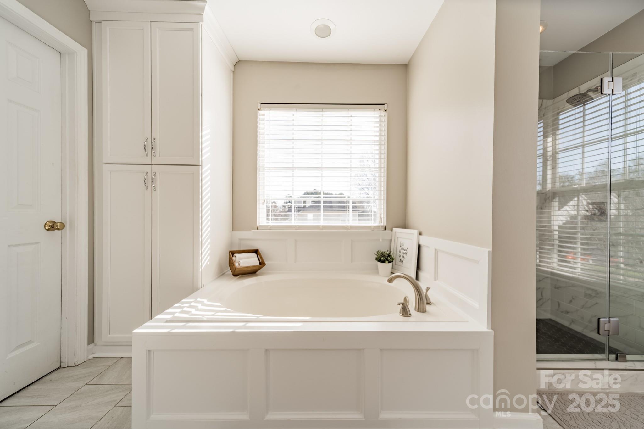 16104 Hollingbourne Road Huntersville, NC 28078 - Photo 33 of 40 a bathroom with bathtub and window
