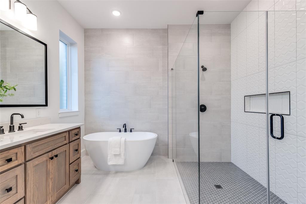 3849 Hawick Lane Dallas, TX 75220 - Photo 12 of 18 Spa-like primary bathroom with a freestanding bath, a large walk-in shower, double vanity, tile walls, and recessed lighting