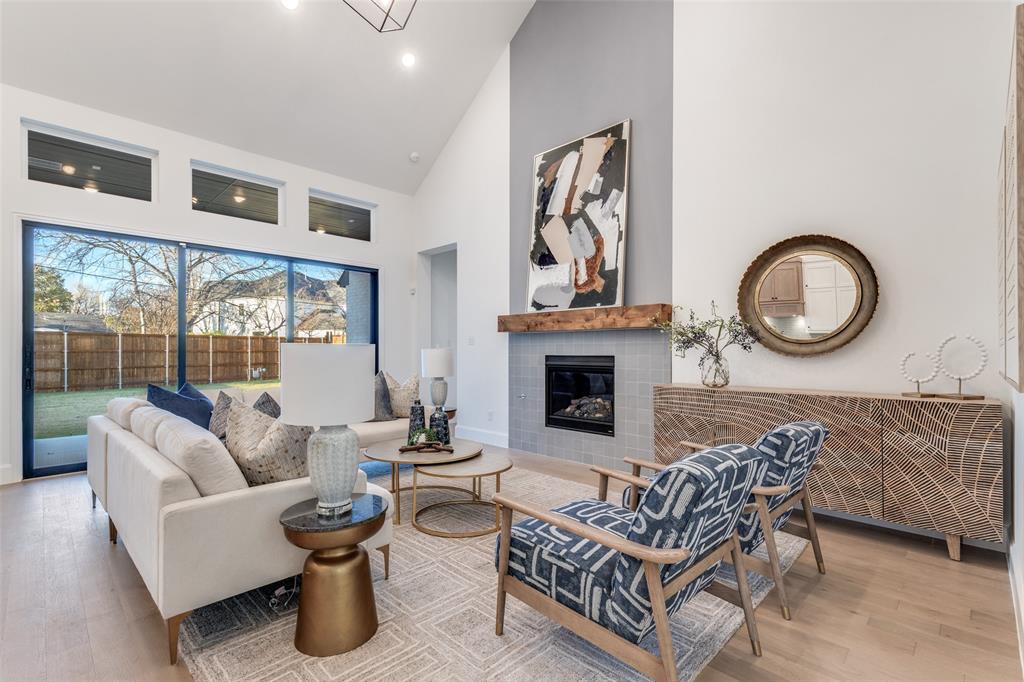 3849 Hawick Lane Dallas, TX 75220 - Photo 5 of 18 Living area with light wood-type flooring, high vaulted ceiling, and a tiled fireplace