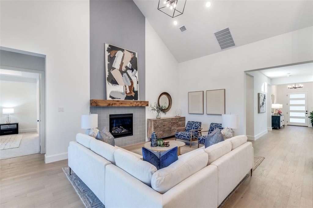 3849 Hawick Lane Dallas, TX 75220 - Photo 6 of 18 Living area with a chandelier, high vaulted ceiling, light wood-style flooring, and a glass covered fireplace