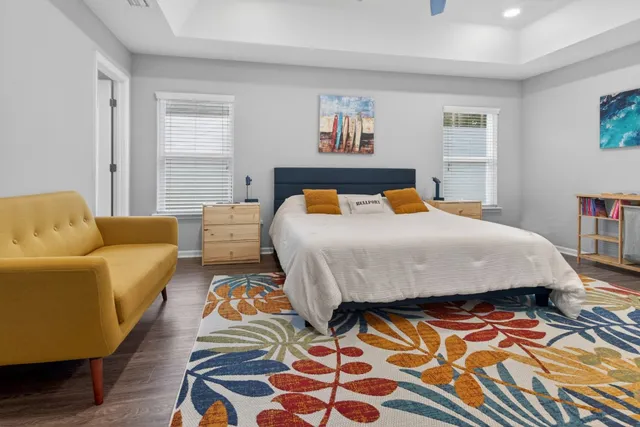 a living room with furniture a flat screen tv and kitchen view