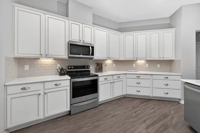 a kitchen with a sink cabinets and wooden floor