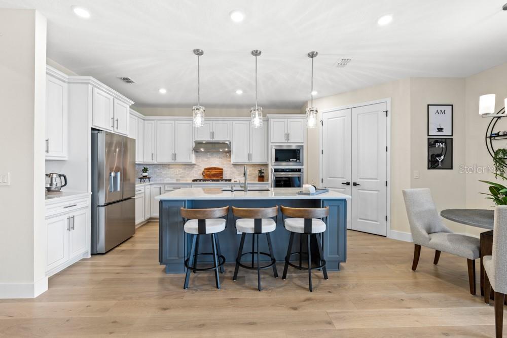 5148 Foothills Preserve Loop Mount Dora, FL 32757 - Photo 2 of 54 a kitchen with stainless steel appliances a dining table chairs refrigerator and microwave