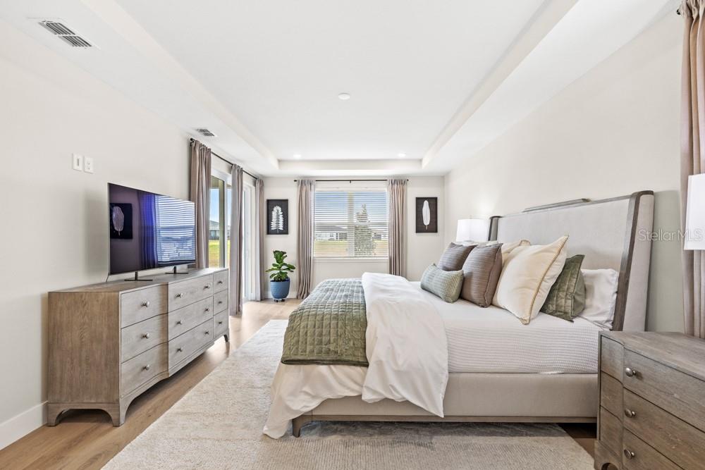 5148 Foothills Preserve Loop Mount Dora, FL 32757 - Photo 25 of 54 a bedroom with a bed and a flat screen tv
