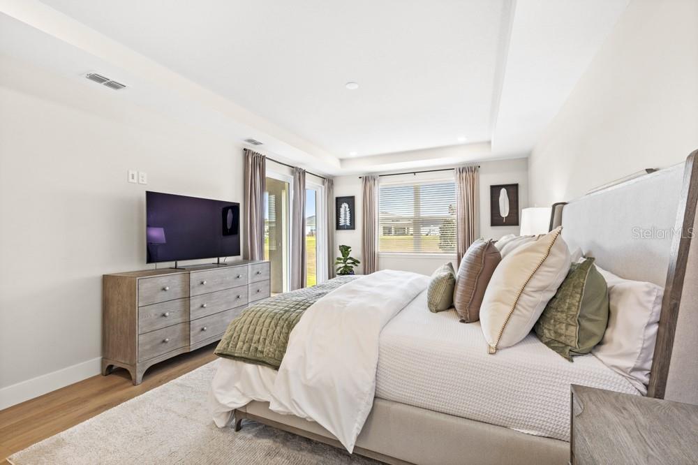 5148 Foothills Preserve Loop Mount Dora, FL 32757 - Photo 26 of 54 a bedroom with a bed and flat screen tv