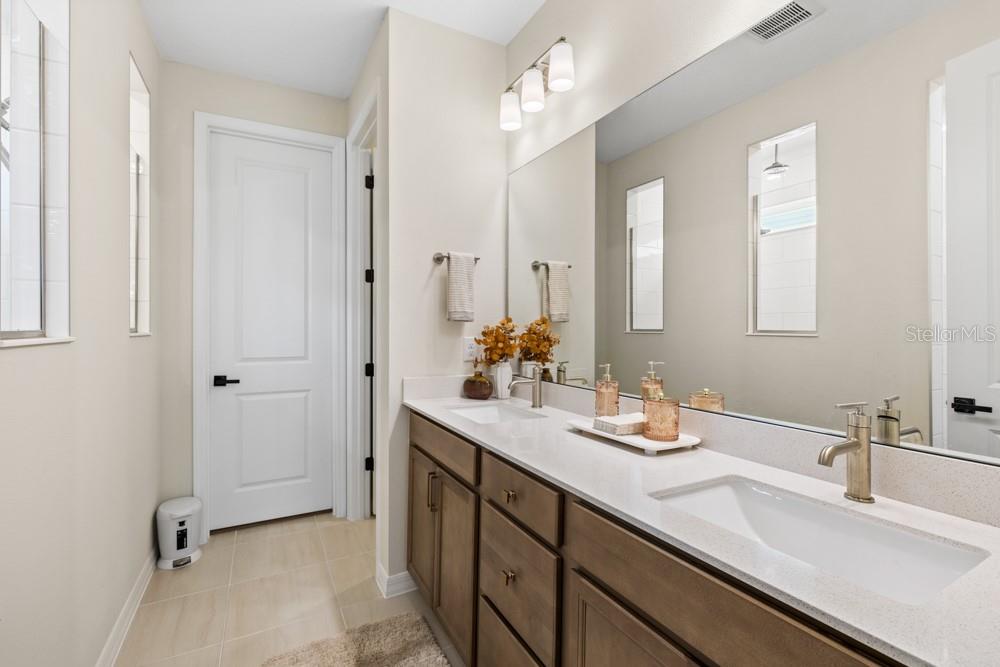 5148 Foothills Preserve Loop Mount Dora, FL 32757 - Photo 28 of 54 a bathroom with a double vanity sink a mirror and a shower