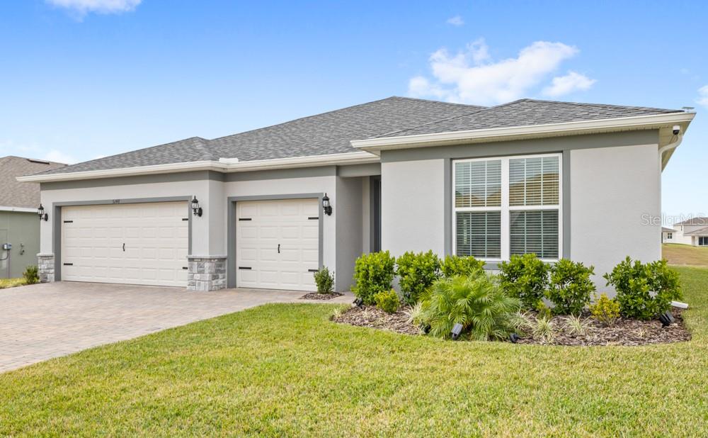 5148 Foothills Preserve Loop Mount Dora, FL 32757 - Photo 41 of 54 a front view of a house with a garden and yard
