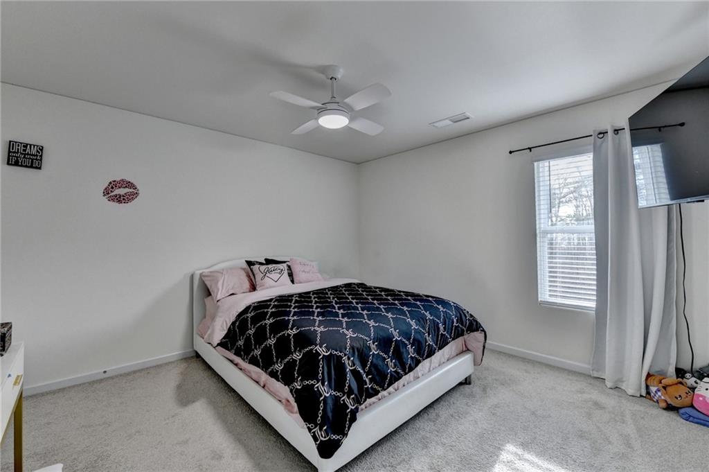 86 Canyon Ferry Way Hoschton, GA 30548 - Photo 19 of 61 a bed sitting in a bedroom next to a window and a larger closet