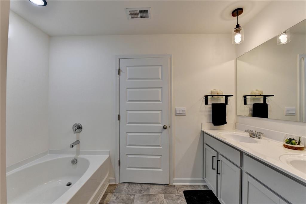 86 Canyon Ferry Way Hoschton, GA 30548 - Photo 40 of 61 a bathroom with a bathtub sink a vanity and shower