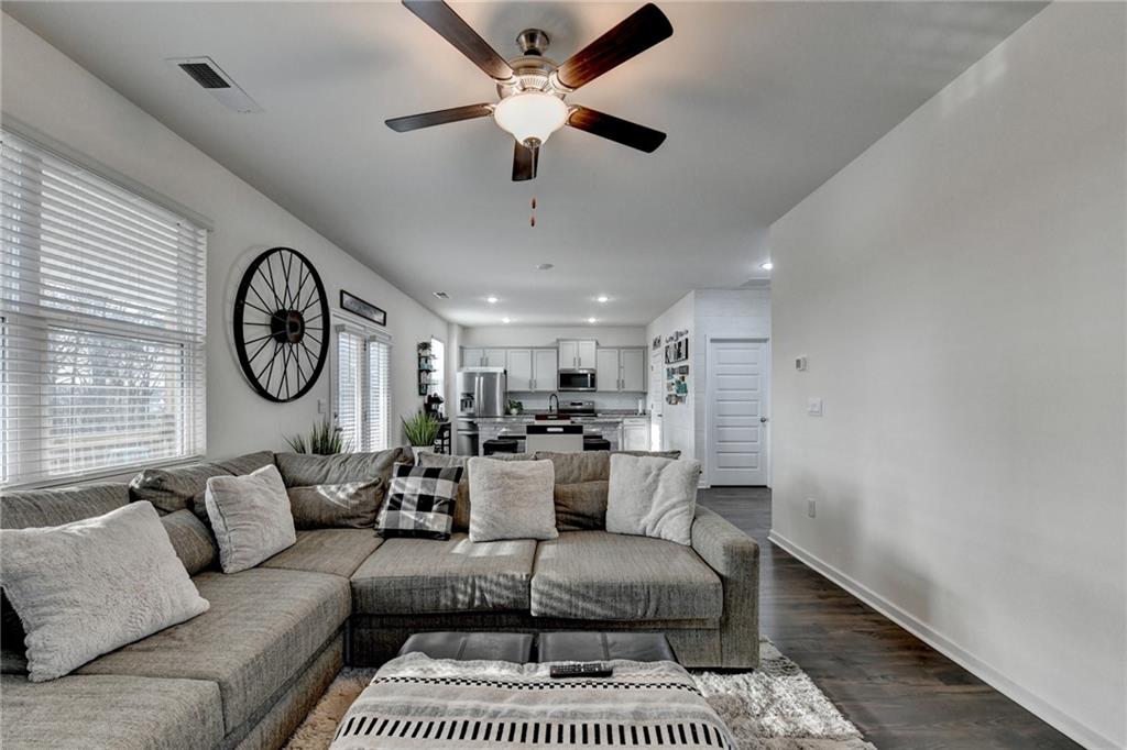 86 Canyon Ferry Way Hoschton, GA 30548 - Photo 7 of 61 a living room with furniture a clock and a ceiling fan
