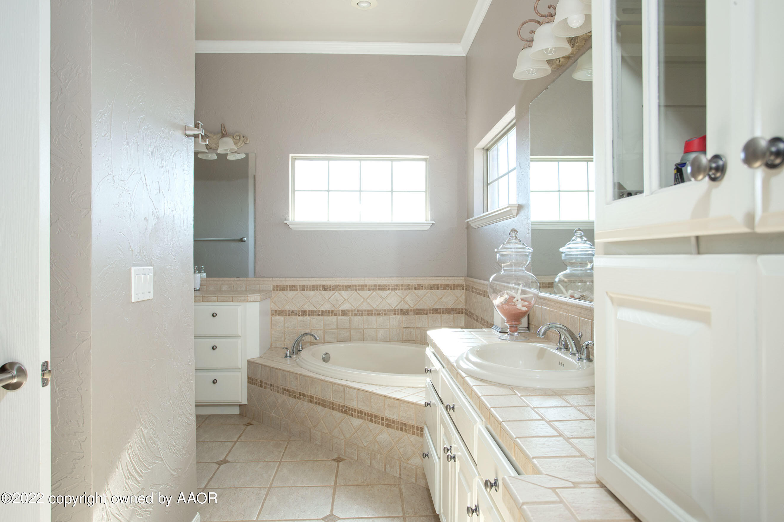 9101 Blackhawk Road Amarillo, TX 79119 - Photo 43 of 73 a bathroom with a granite countertop sink a mirror and a bathtub
