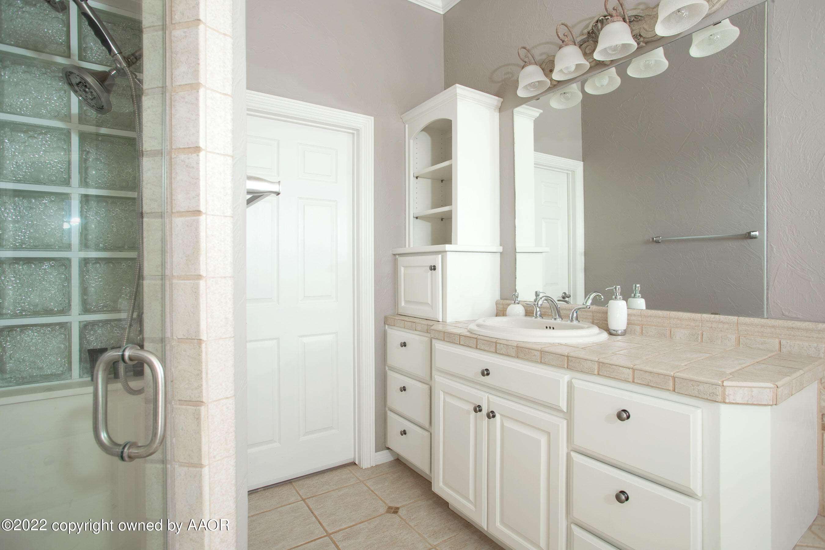 9101 Blackhawk Road Amarillo, TX 79119 - Photo 44 of 73 a bathroom with a granite countertop sink a shower and a mirror