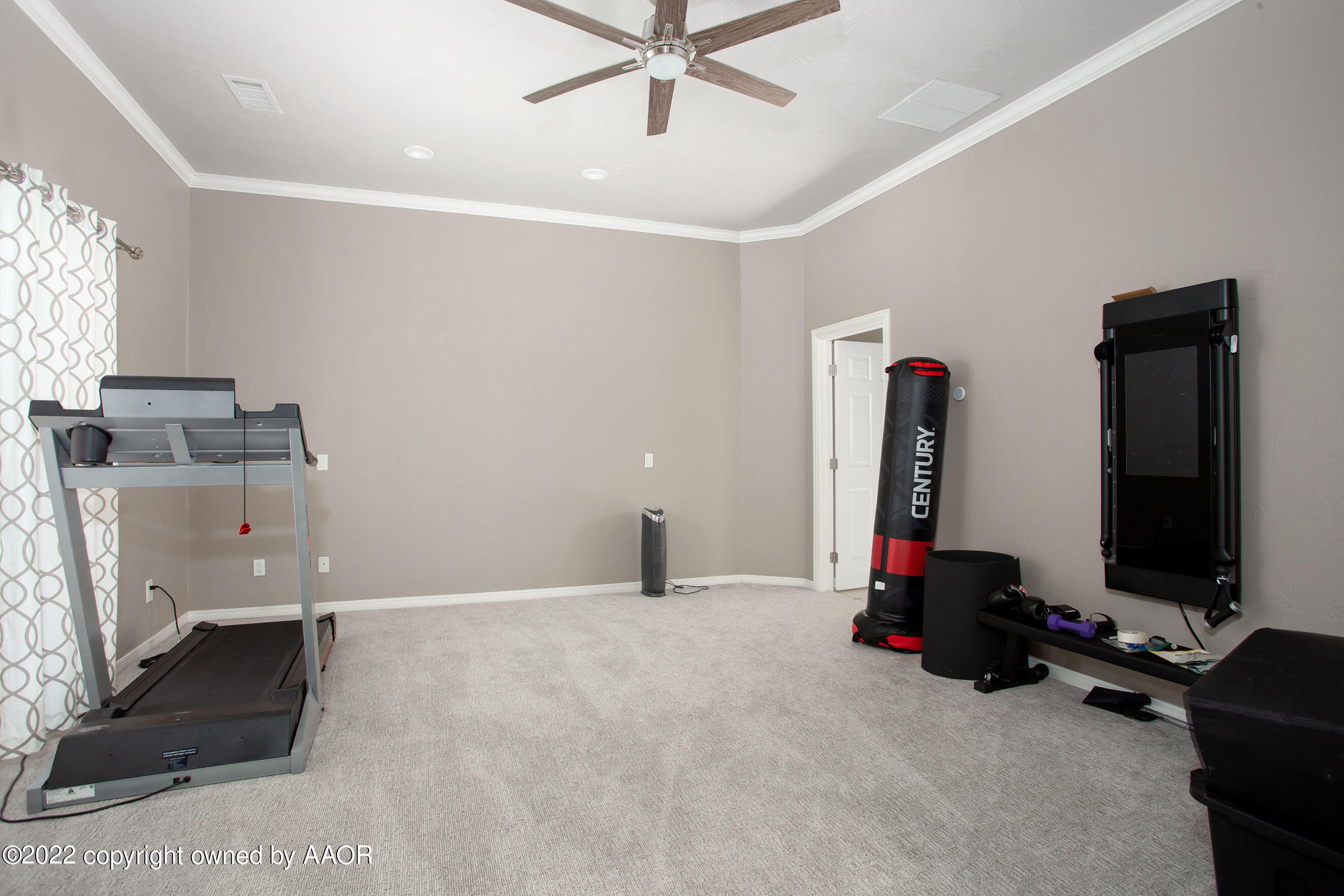 9101 Blackhawk Road Amarillo, TX 79119 - Photo 46 of 73 a room with gym equipment and a flat screen tv