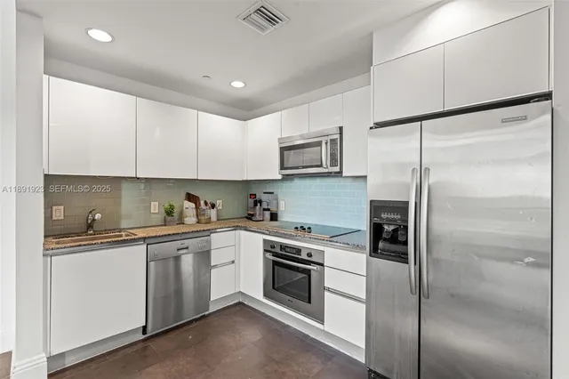 a kitchen with a sink stainless steel appliances and cabinets