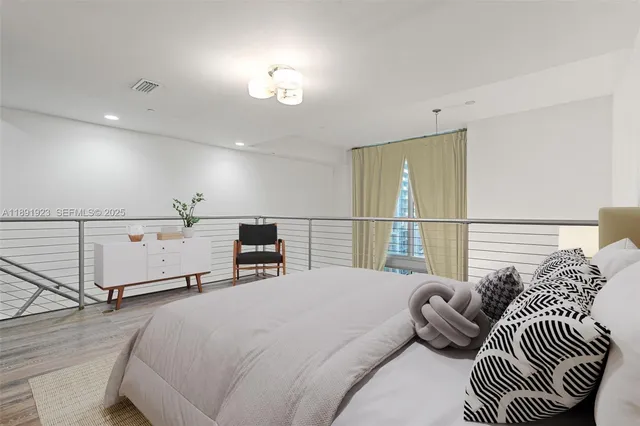 a spacious bedroom with a bed and a chandelier