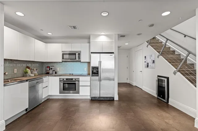 a kitchen with granite countertop a stove top oven and refrigerator