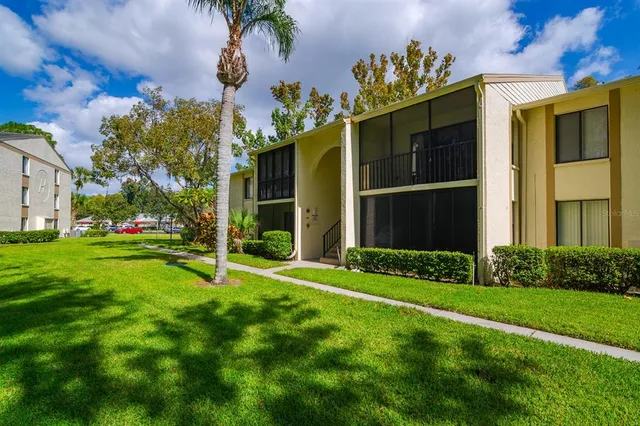 a view of a house with a big yard and large tree