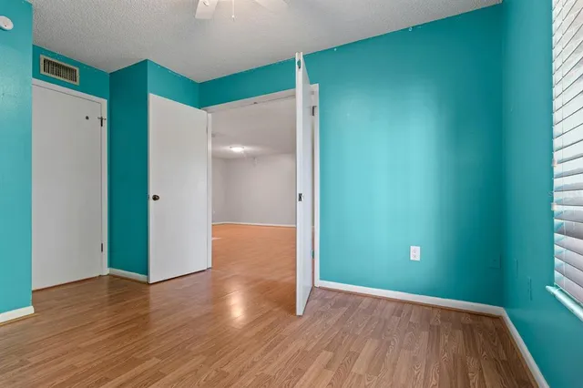 a view of empty room with wooden floor