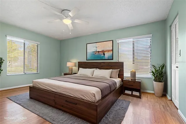 a view of house with a big yard and large trees
