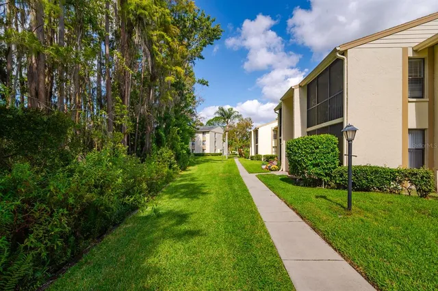 a view of a house with a big yard and large trees
