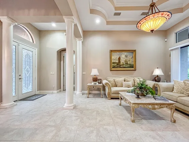 a living room with furniture a chandelier and outdoor view