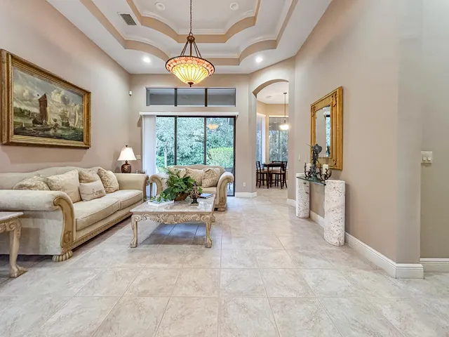 a living room with furniture a chandelier and a dining table