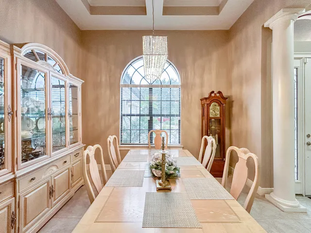 a view of a dining room with furniture a chandelier and wooden floor