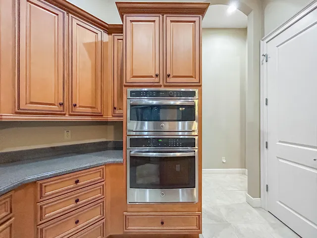 a kitchen with granite countertop white cabinets and stainless steel appliances