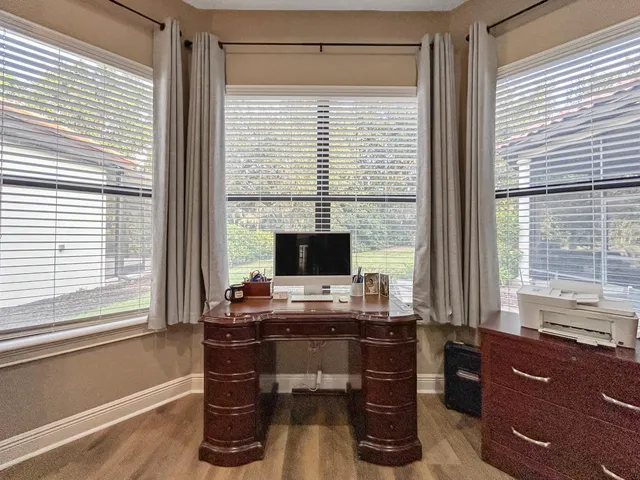 a view of a workspace with furniture and a window