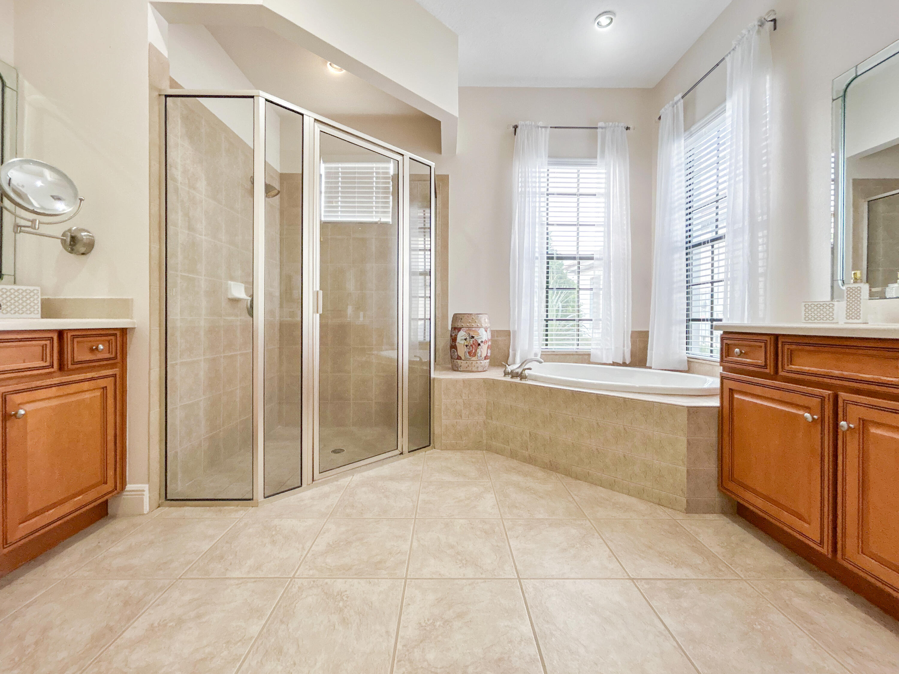 26345 San Gabriel Howey-in-the-Hills, FL 34737 - Photo 33 of 51 a spacious bathroom with a granite countertop sink a mirror a bathtub and next to a window