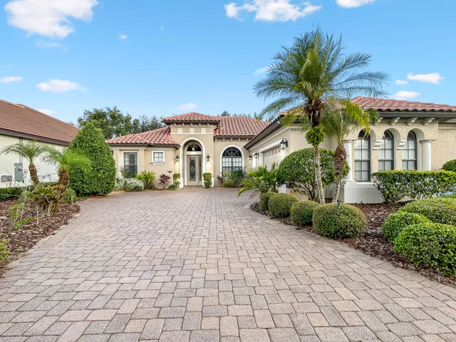 a front view of a house with a yard and potted plants