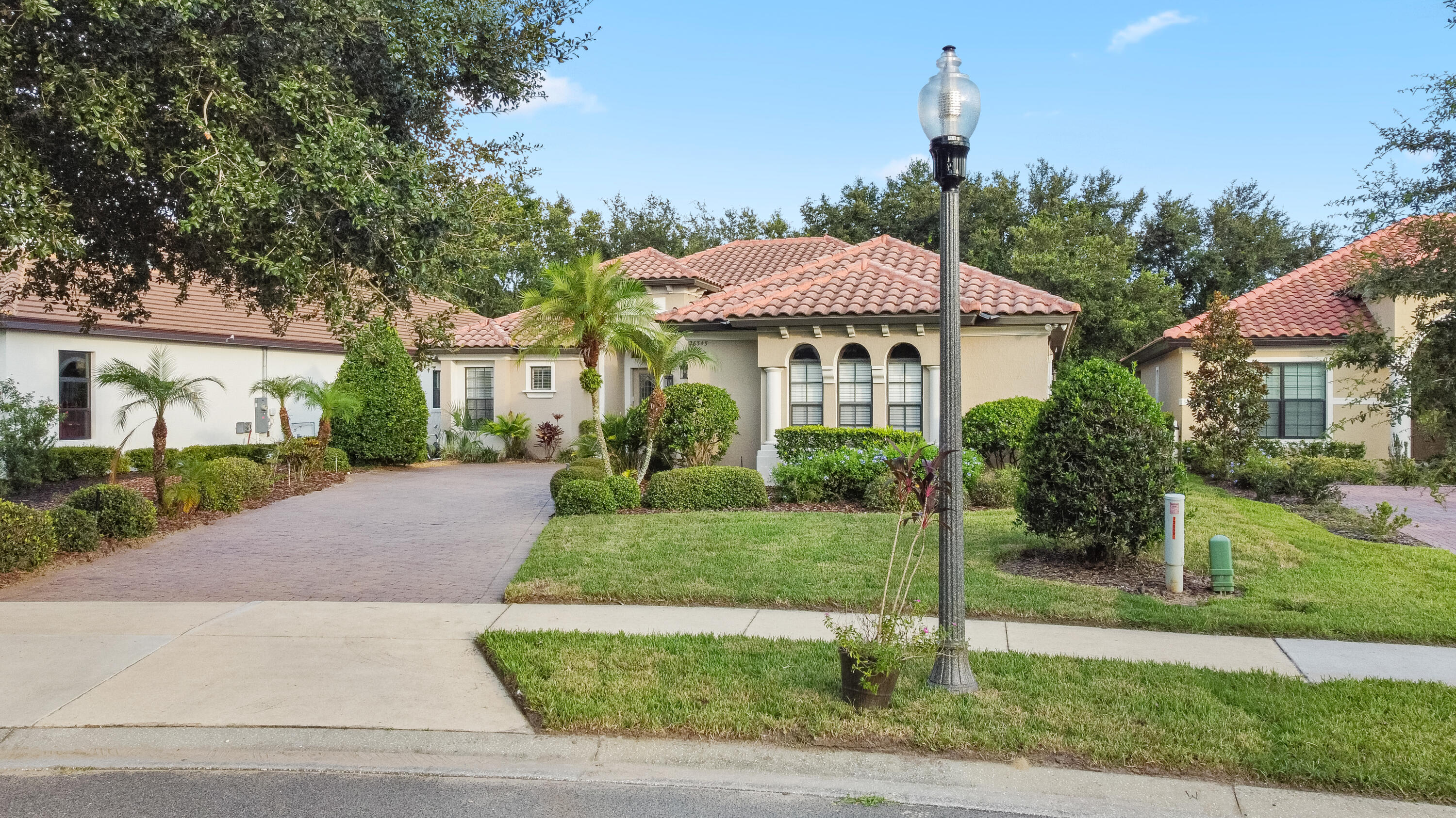 26345 San Gabriel Howey-in-the-Hills, FL 34737 - Photo 7 of 51 a view of a house with a yard and table and chairs under an umbrella
