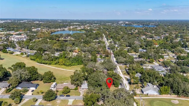 an aerial view of residential houses with outdoor space and trees