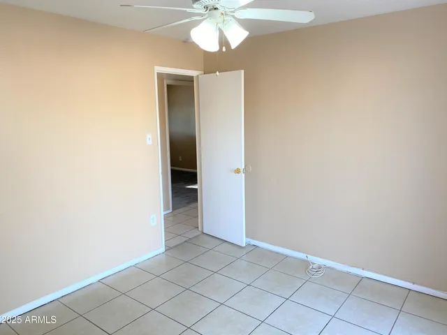 an empty room and chandelier fan