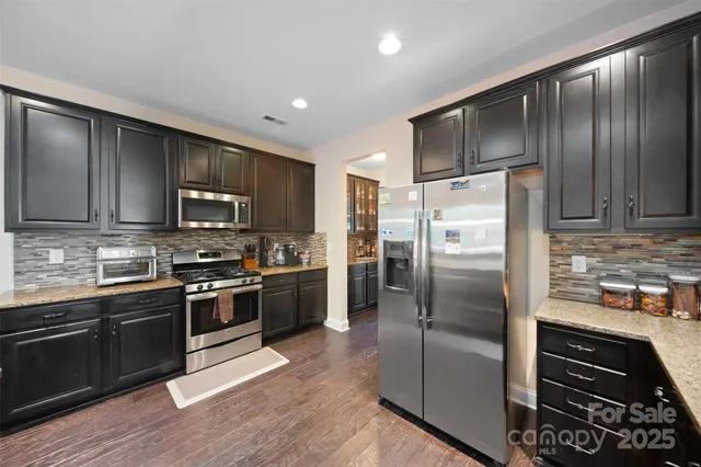 a kitchen with granite countertop stainless steel appliances and wooden cabinets