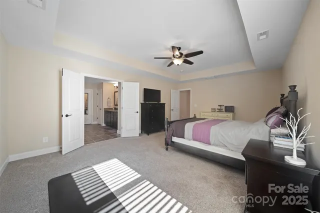 a spacious bedroom with a bed and a chandelier