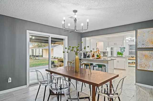 a view of a dining room with furniture a chandelier and wooden floor