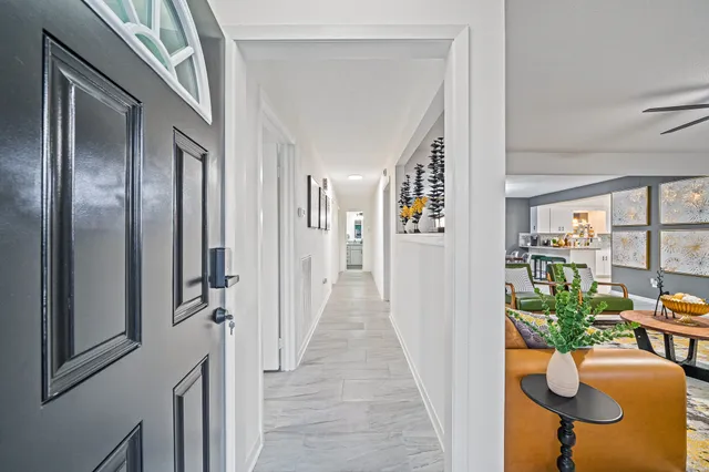 a view of a hallway with chairs and flower pot