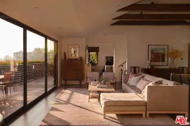 a living room with furniture and a floor to ceiling window