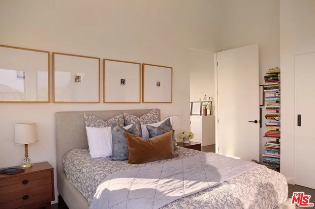 a bedroom with bed and wooden floor