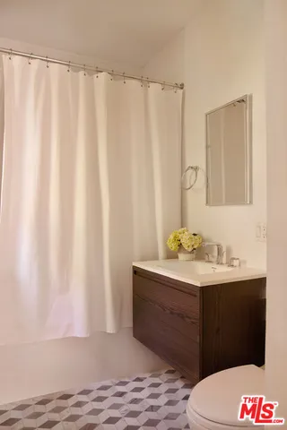 a living room with furniture a flat screen tv and kitchen view