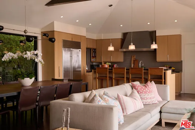 a living room with stainless steel appliances kitchen island granite countertop furniture and a view of kitchen