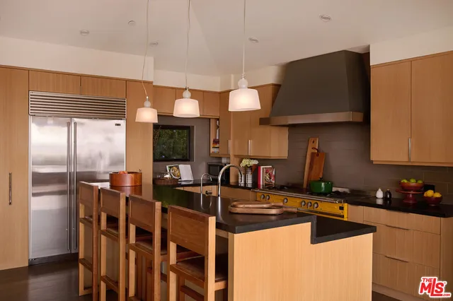 a kitchen with stainless steel appliances granite countertop a sink a stove and a refrigerator