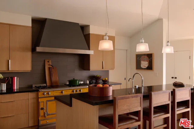 a kitchen with a table chairs sink and cabinets