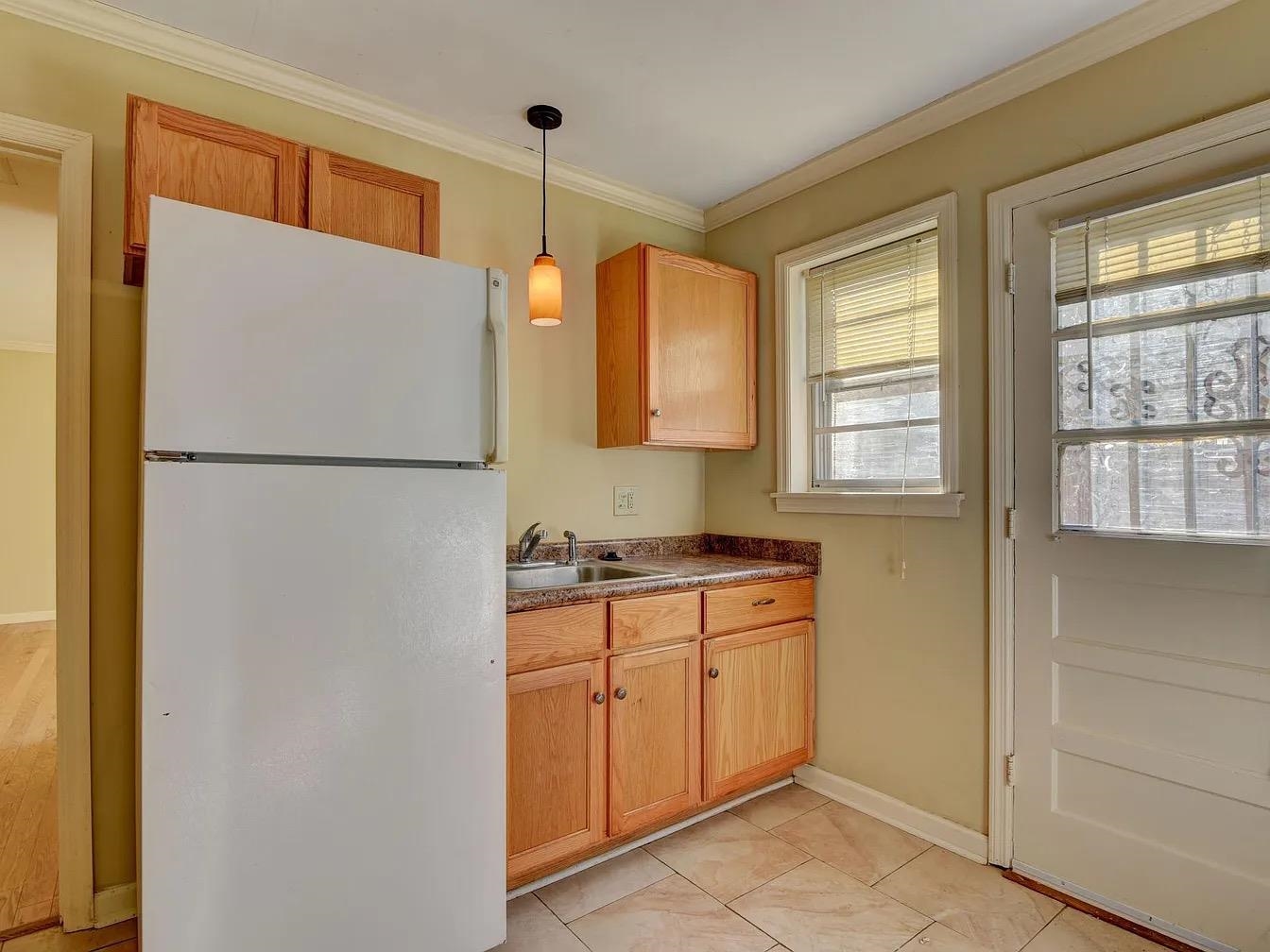 370 South Fenwick Road Memphis, TN 38111 - Photo 5 of 13 Kitchen with freestanding refrigerator, pendant lighting, crown molding, dark countertops, and light tile patterned floors